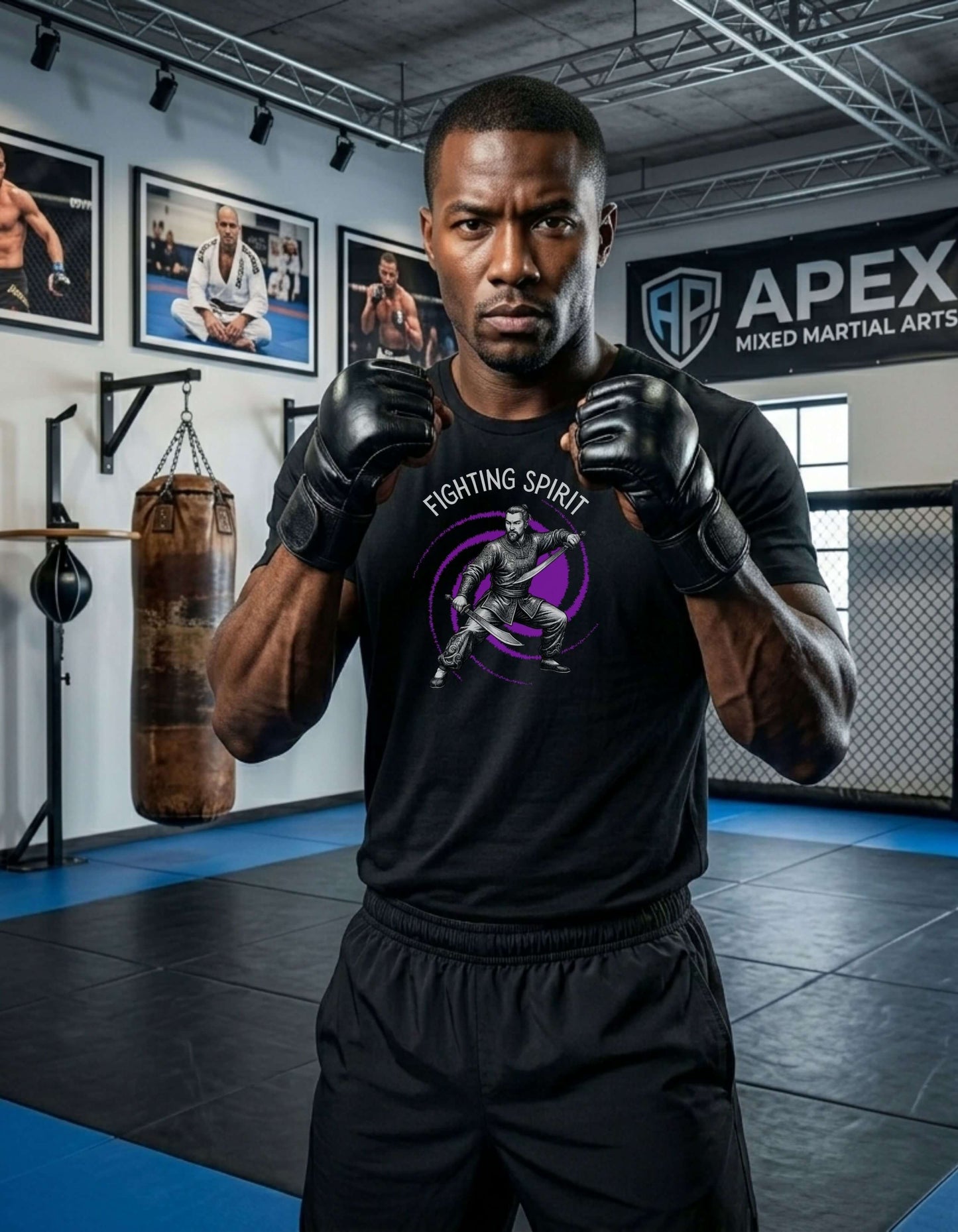 Man in a martial arts gym fists up, wearing a black t-shirt with the slogan - Fighting Spirit printed in white, above the bold graphic of a male warrior in fight stance, wielding dual swords in front of a vivid purple swirling vortex.